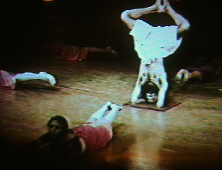A group of people doing yoga on a wooden floor

Description automatically generated