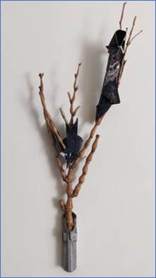 A tree branch with a metal object on it

Description automatically generated