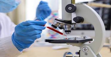 A person holding a microscope
Description automatically generated