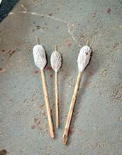 A group of bamboo sticks with white yarn

Description automatically generated