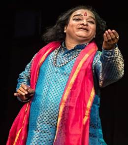 A person wearing a blue dress and red scarf

Description automatically generated