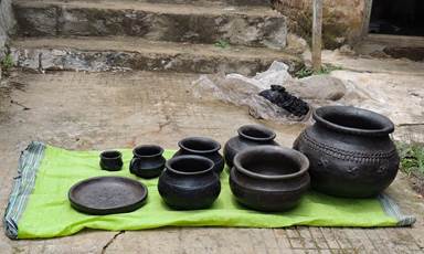 A group of pots on a green surface

Description automatically generated