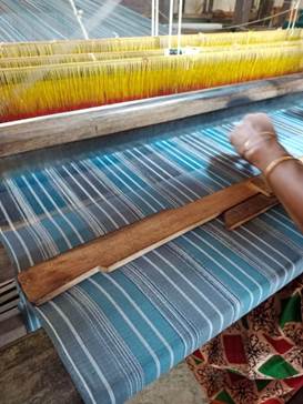 A person using a loom

Description automatically generated