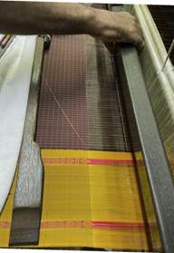 A close-up of a weaving machine

Description automatically generated