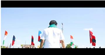 A person standing in front of flags

Description automatically generated with low confidence