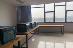 A room with a few tables and a window

Description automatically generated