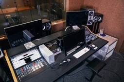 A desk with a computer and speakers

Description automatically generated