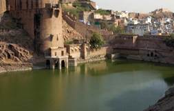 A water body with a castle in the background

Description automatically generated