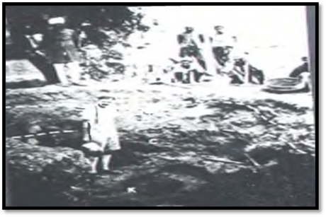 A group of people standing in the dirt

Description automatically generated